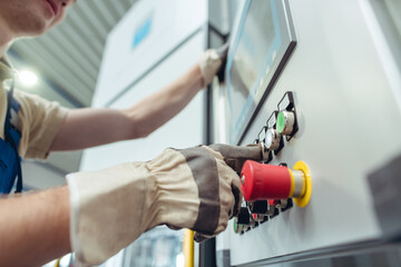 Manufacturing worker pressing button of metal bending machine