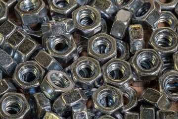 A pile of hex nuts on a workbench