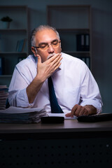 Old male employee working late in the office