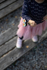 The little girl holds her hands and eats sushi.