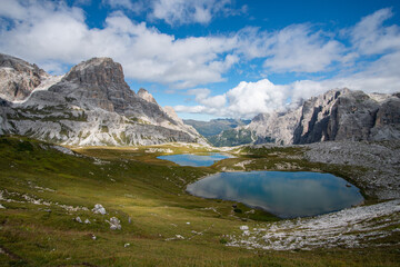 an alpine lake with the reflection of the mountains in the Dolomites in South Tyrol,  Italy