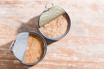 Open can of tuna on wooden background, close-up image - obrazy, fototapety, plakaty