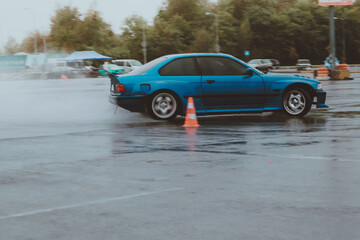 Cars are drifting in the old parking lot. Rain drift. Gray photo processing, atmosphere. Racing in the city. © Yaroslav