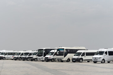 Row of Minibuses and Buses on clean sky background