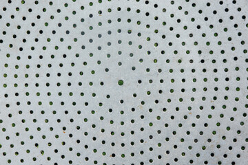 The surface of an old aluminum sheet with concentric circular holes. Vintage kitchen colander. Background. Texture. Abstraction.
