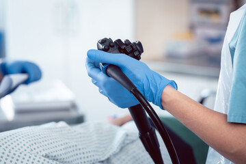 Doctor holding endoscope during colonoscopy - 381482896