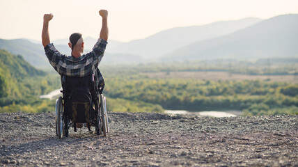 Young retired military man in a wheelchair enjoying the fresh air on a sunny day on the mountain.