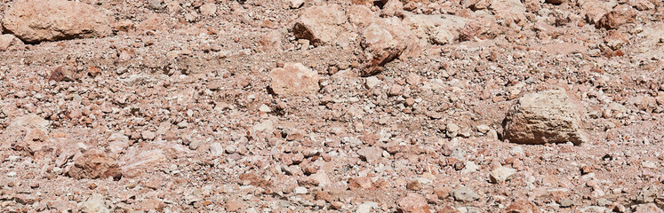 desert bed of a melted glacier made of reddish stones, reminiscent of a Martian landscape