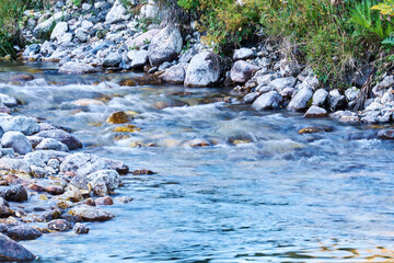 clean mountain stream in rocky shores blurred in motion