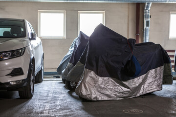 Motorcycles are wintering in warm parking lot close to passenger car