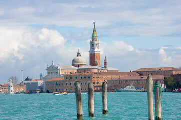 Fototapeta premium Venice, Basil. of San Marco and the tower bell from la Gudecca, island traditional venetian offshore boat, sunny day