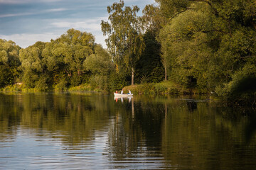 autumn park. people are boating on the pond against the background of beautiful multicolored trees.