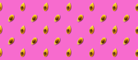 Colored pattern of passion fruit seeds on a pink background.