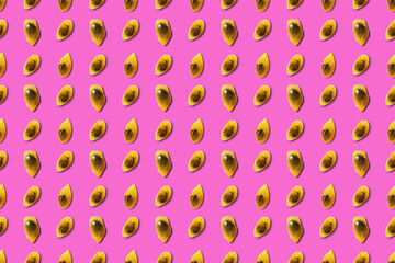 Colored pattern of passion fruit seeds on a pink background.