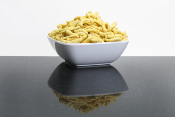 Indian snacks food gathiya sev in white bowl in white background.