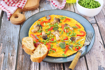 Omelet with green peas, red bell pepper and mushrooms