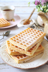 Belgian waffles and honey, cup of tea for sweet  breakfast