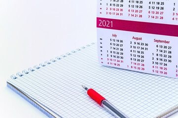 Red pen and Notepad on a white background. Notepad and calendar.