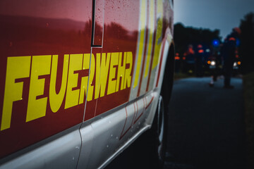Jugendfeuerwehr macht Übung bei Nacht im Regen mit Feuerwehrfahrzeug
