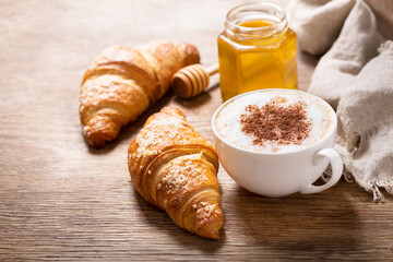 cup of cappuccino coffee and croissants