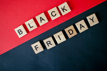 The inscription black friday from wooden blocks on a black and red background