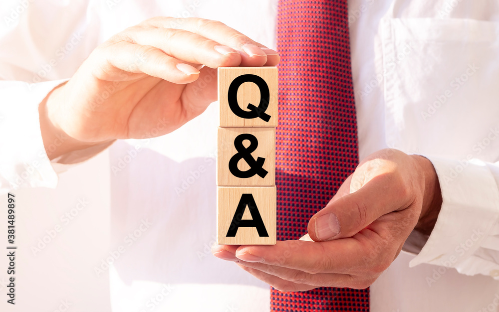 Poster questions and answers concept - q and a - wooden cube blocks in male hands