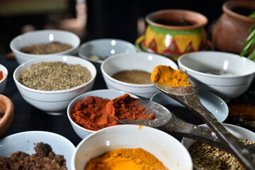 Various spice on wooden spoons with herbs