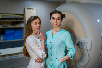 Two professional radiologist. Female doctors are posing near MRI or CT machine. Neurology and neurosurgery concept.