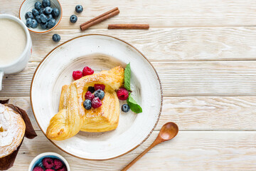 Delicious sweet pastry made from puff pastry. Cake with fresh berries on a wooden background. Copy spice
