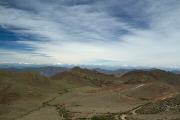 Aerial view of the enchanted Valley in Salta, Argentina. The green meadow, valley and hills under a beautiful blue sky with clouds. 