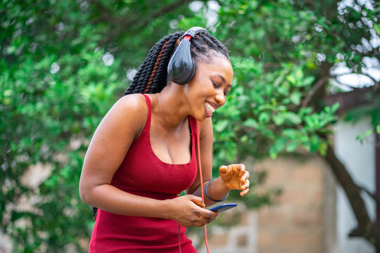 image of beautiful braided African lady with head phone - music concept