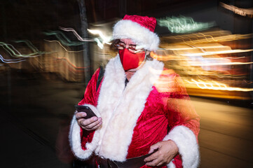 Santa Claus with a mask talking on the phone in the city of Madrid.