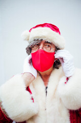 Fototapeta premium Santa Claus walking through the streets of the city of MadridSanta Claus putting on a mask in the city of Madrid.