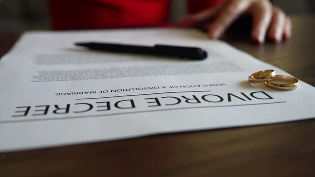 Wife signing decree of divorce agreement prepared by lawyer.