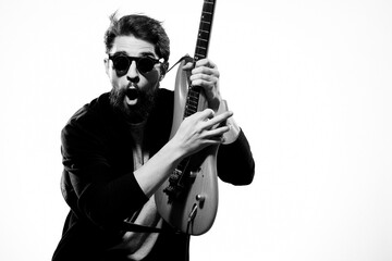 Obraz premium man with guitar in hands musician rock star performance lifestyle light background