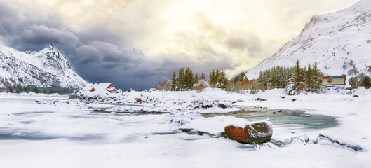 Dramatic winter scenery with snowy  mountain peaks  on the shore of Rolvsfjord on Vestvagoy island at Lofotens.