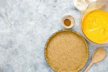 Cooking squash pie or pumpkin tart. Top view of crust and pumpkin filling. Autumn dessert.