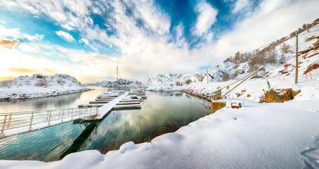 Charming winter scenery with yachts and boats nier pier in small fishing village and snowy  mountain peaks near Valberg