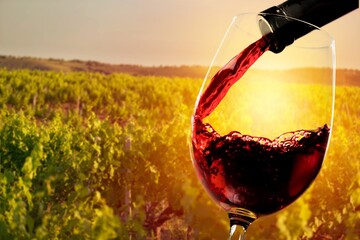 Red wine pouring from the bottle in glass
