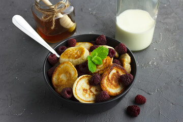 Traditional dutch mini pancakes or poffertjes with raspberry and mint