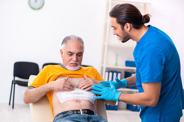 Obraz premium Old man visiting young male doctor