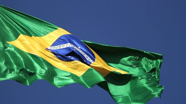 Brazilian flag blowing in the wind. Brazil, real video, blue sky