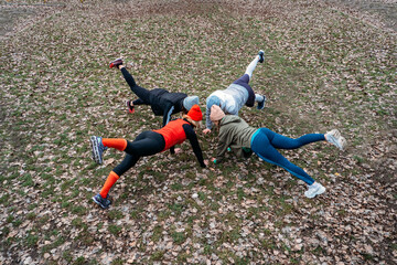 Group fitness classes outdoors. Organized gym classes set up in public parks. Three women and man training together in the public park. Health, wellness and community concept