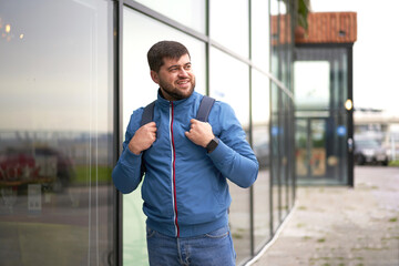 Fototapeta na wymiar Bearded Tourist Man with backpack enjoy beautiful view of modern city