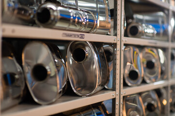 Set of new metallic mufflers car parts before distribution and retail. Close Up.