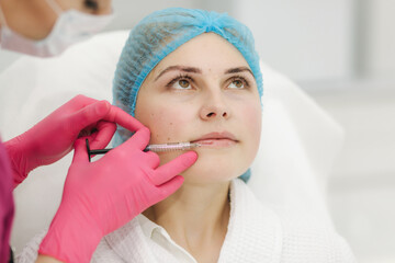 Lip augmentation. Woman getting beauty injection for lips in beauty salon