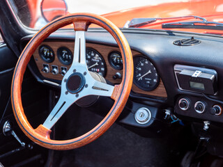 The steering wheel and dashboard of an antique classic car