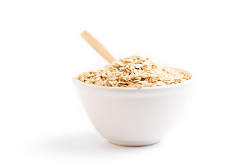 Oat flakes on a bowl and a wooden spoon