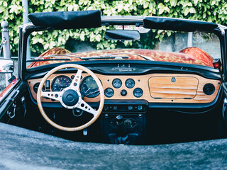 The steering wheel and dashboard of an antique classic car