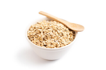 Oat flakes on a bowl and a wooden spoon